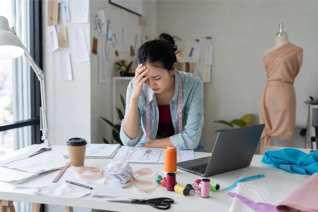 Sad fashion designer worried about client acquisition